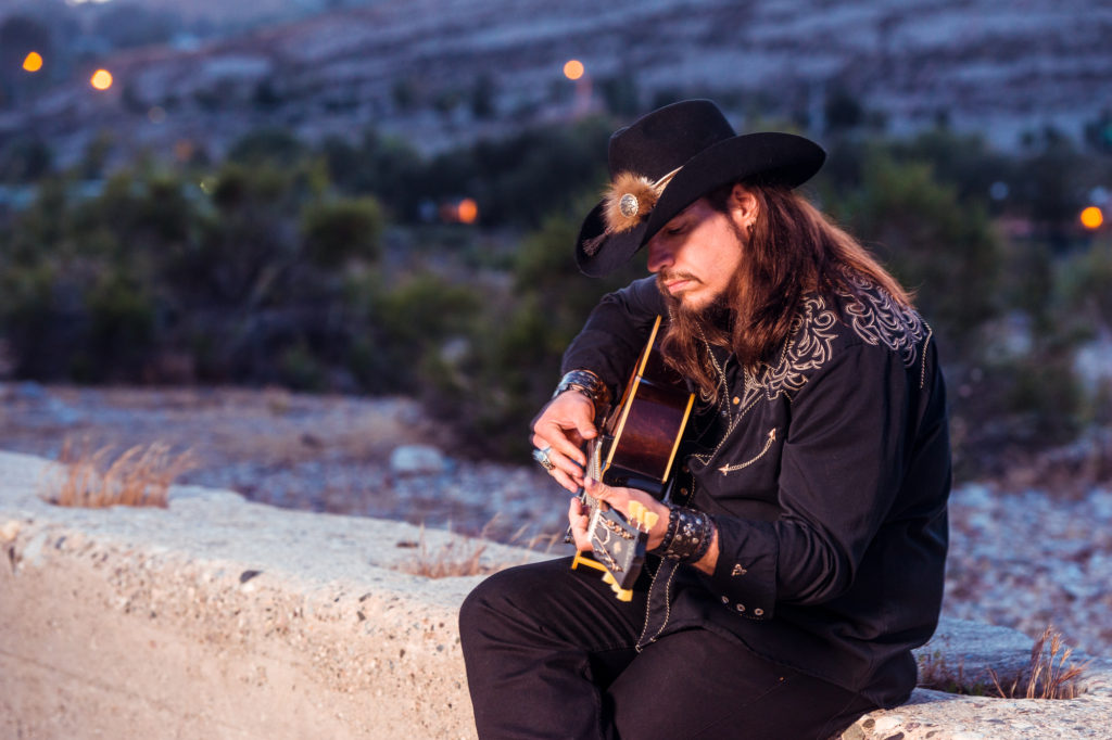 photo of Lance Lopez by Alex Solca sitting player guitar at dusk