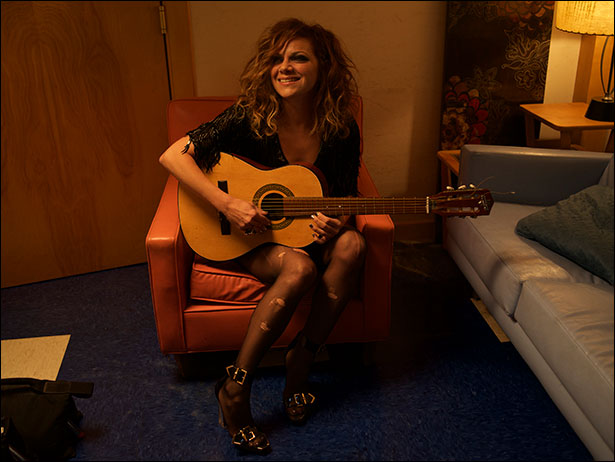 photo of Nikka Costa sitting playing guitar