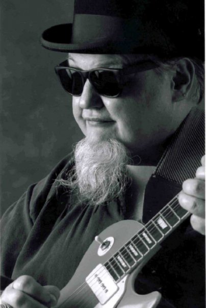 black and white image of blues singer songwriter Bryan Lee holding a guitar